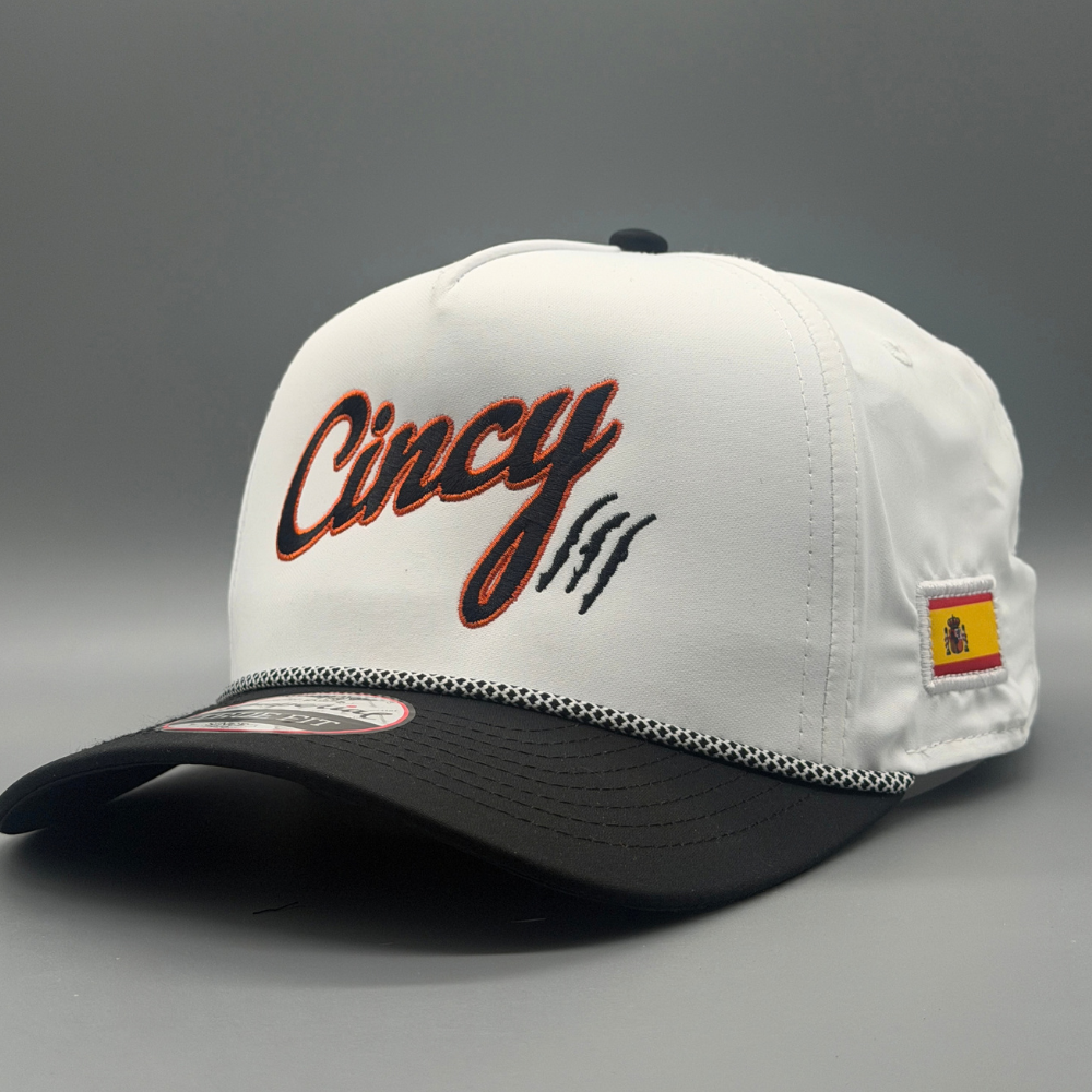 Two-tone OG 5 Panel hat with white crown, black brim, black Cincy script outlined in orange, and Spanish flag patch