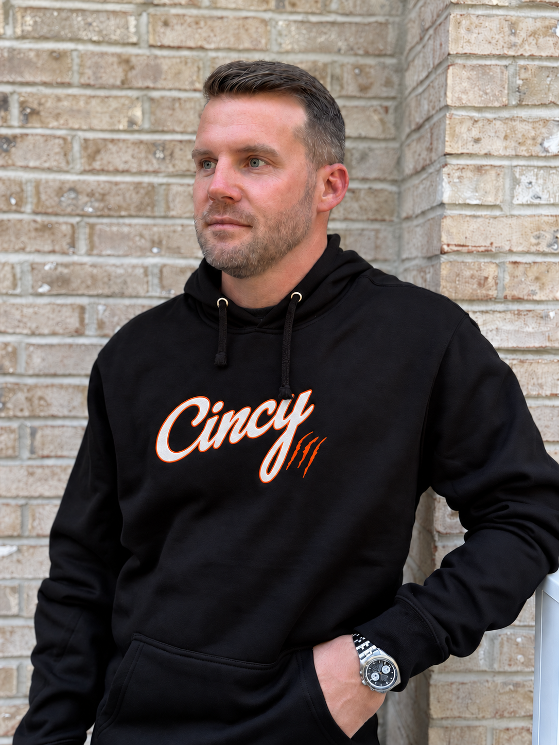 Model wearing black Cincy hoodie with white and orange chest logo