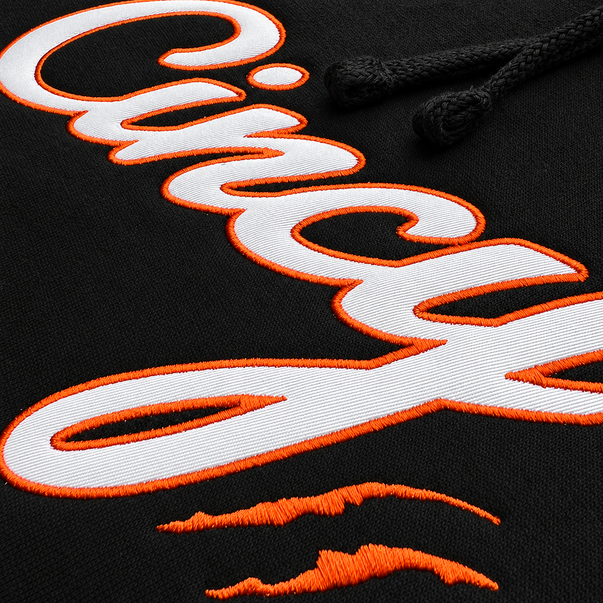 Close-up of white Cincy twill lettering with orange embroidered edges on black hoodie