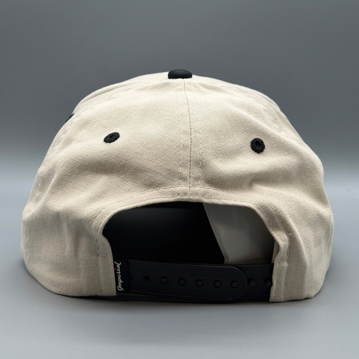 Front view of the putty and black Washed Cotton Two Tone hat with puffed black Cincy script logo