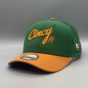 Angled view of The Mallard cap showing the green crown, gold brim, Cincy logo, and side mallard duck embroidery