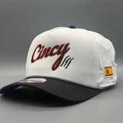 Two-tone OG 5 Panel hat with white crown, black brim, black Cincy script outlined in orange, and Spanish flag patch