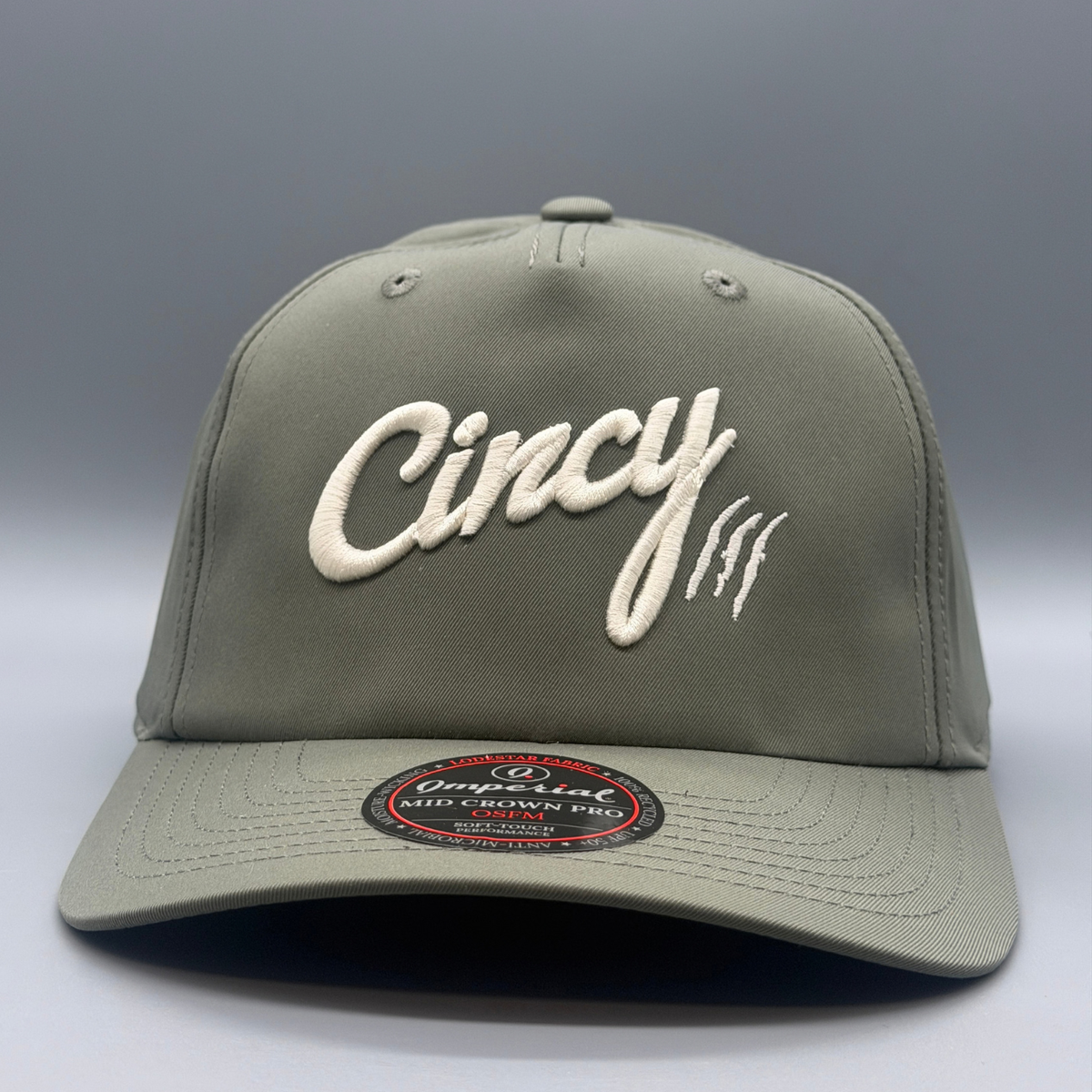 Angled view of the olive Mid-Crown 5 Panel hat with puffed cream Cincy script logo