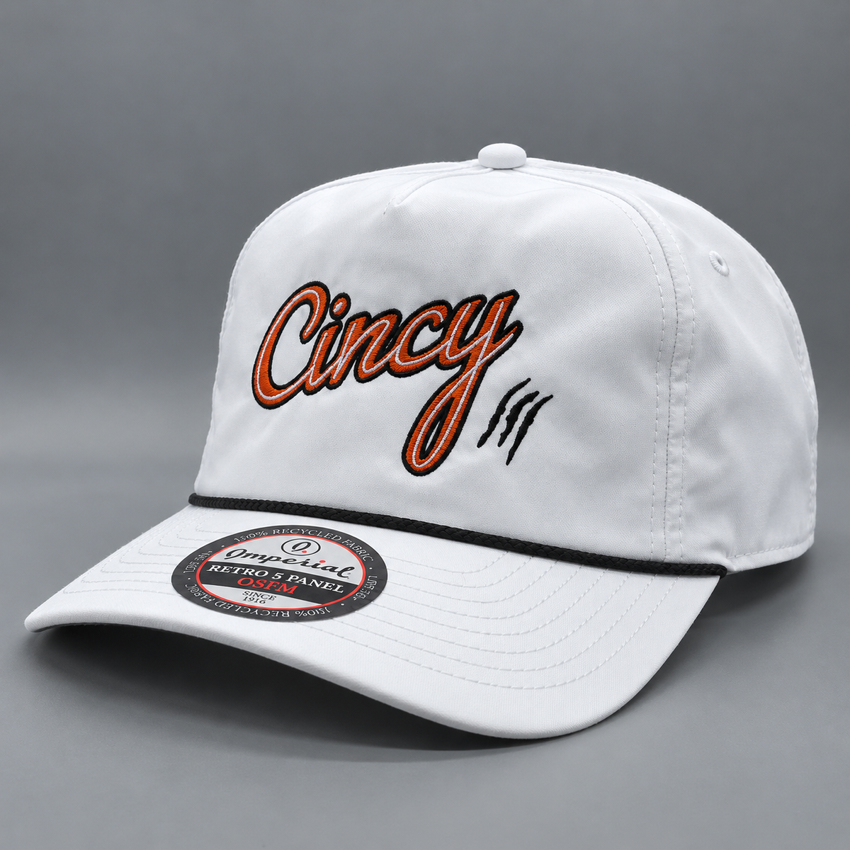 The Queen City Script – White hat with orange Cincy script, black accents and black rope, photographed at a three-quarter angle.